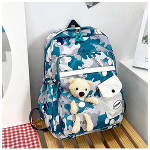 Detail of camouflage backpack with plush bear pendant and fashion pocket label