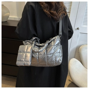 Detail of silver quilted tote bag with matching pouch shown on a fashion model