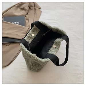 Detail view of green faux shearling tote bag showing magnetic closure and inner pocket