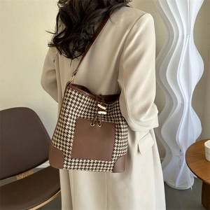 Classic houndstooth bucket shoulder bag in brown and beige with drawstring and metal accents