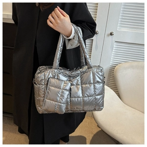 Detail view of metallic silver quilted tote bag with matching mini pouch accessory