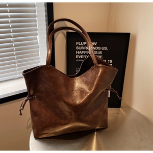 Detailed view of dark brown faux leather tote bag with vintage wax texture and side drawstrings