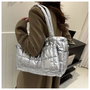 Silver quilted tote bag with matching shoulder strap and small detachable pouch on a model