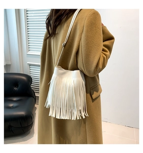 White bohemian crossbody phone bag with long tassels on stylish khaki wool coat