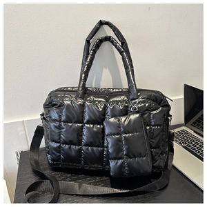 Close-up of black quilted puffer tote bag set with shiny finish and small zipper pouch
