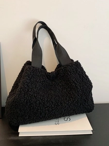 Fuzzy black fleece tote bag with wide strap for winter casual style on white background