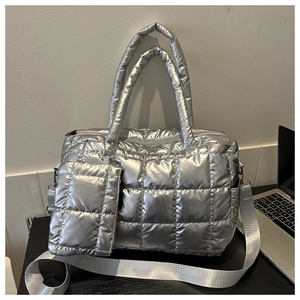 Detailed macro view of a silver quilted tote bag featuring metallic finish and small pouch