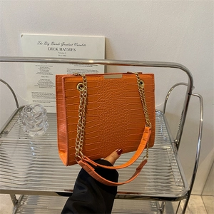 Chic orange faux crocodile leather tote bag with elegant gold chain shoulder strap