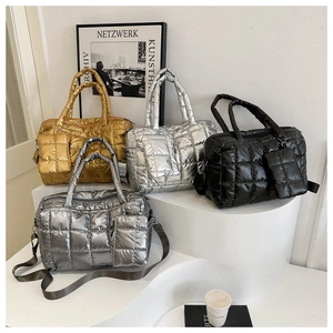 Detailed view of quilted puffer tote bags in metallic gold, silver, grey, and black finishes