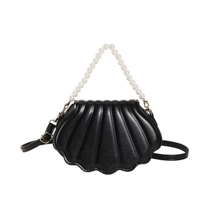 Minimalist black shell-shaped crossbody bag with pearl handle and adjustable strap