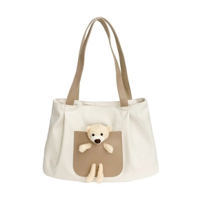 Cream canvas tote bag with brown straps and a cute plush bear peeking from the front pocket