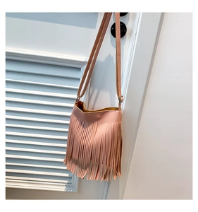 Detailed view of pink lychee leather crossbody bag with stylish long tassel decoration