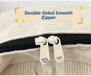 Detailed macro view of beige corduroy fabric with a smooth double black metal zipper