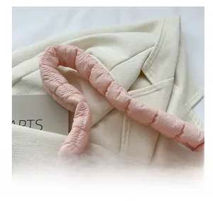 Detail of pink quilted handbag showing soft padded handle and fluffy down-like texture