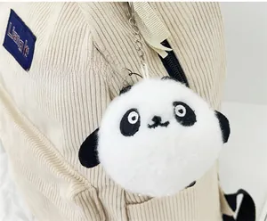 Close-up of a cute plush panda charm attached to an off-white corduroy backpack