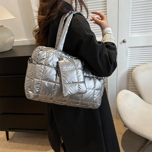 Metallic silver quilted tote bag with matching coin purse shown on female model back view