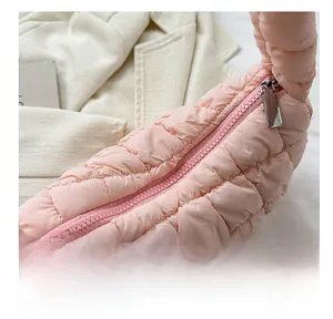 Close-up of pink quilted puffer bag showing smooth metallic zipper and stitching details