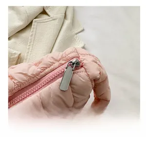 Close-up of pink puffer bag with horizontal quilting and smooth matching zipper