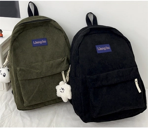 Detail of corduroy backpacks in army green and black with cute plush panda keychains