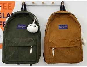 Detail of corduroy backpacks in green and yellow with cute panda plush keychains