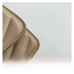 Close-up of khaki quilted faux leather bag showing precise stitching and grid texture
