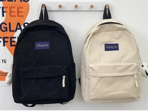 Detailed corduroy backpacks in black and beige with cute teddy bear charms and logo patch