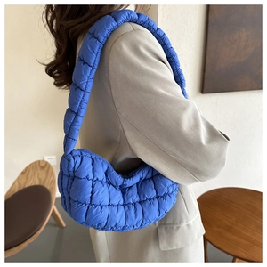 Detail view of Klein blue quilted nylon shoulder bag with soft padded texture and wide strap
