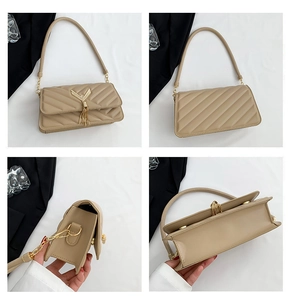 Detail view of beige quilted shoulder bag featuring gold V-shaped hardware and chain tassel