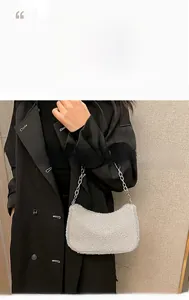 Vue détaillée du sac croissant en faux mouton gris avec une bandoulière chaîne argentée