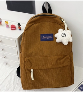 Detailed texture of brown corduroy backpack with a cute star plush keychain accessory