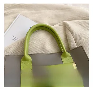 Close-up of the reinforced green handles and front pocket with magnetic clasp on the tote bag