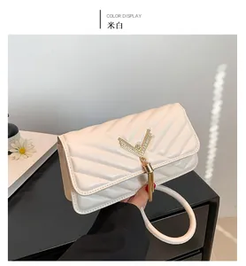 Detail view of the off-white quilted handbag with golden V-metal buckle and tassel