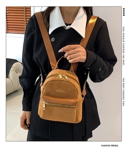 Gros plan du mini sac à dos en daim jaune avec fermeture dorée et étiquette mode