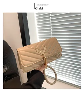 Detail of khaki quilted handbag with gold V-hardware and elegant tassel pendant