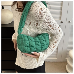 Close-up of quilted puff shoulder bag in emerald green with wide soft strap
