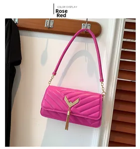 Close-up of fuchsia quilted shoulder bag with V-shaped texture and long metal tassel