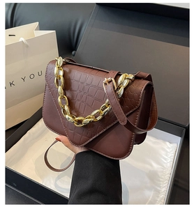 Detail of dark brown stone pattern bag with gold chain strap in a gift box
