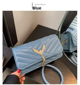 Detail of light blue crossbody bag with V-shaped quilting, gold hardware, and tassel