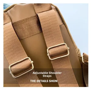 Détail des bandoulières réglables en nylon marron avec boucles dorées sur le sac texturé