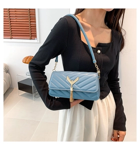 Blue quilted shoulder bag with gold V-metal hardware and tassel fringe detail