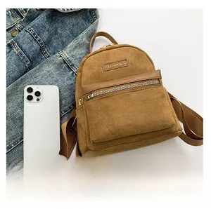 Détail d'un sac à dos marron texture daim avec poche avant zippée et logo tendance