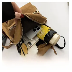 Intérieur du sac à dos en daim marron montrant le rangement pour téléphone et accessoires
