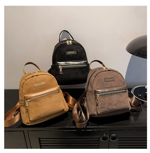 Trois sacs à dos minimalistes en daim en noir, jaune et marron sur une surface en bois