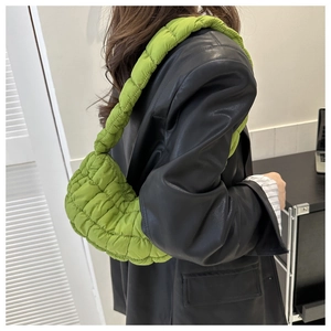 Detail of lime green quilted puffy shoulder bag with soft pleated texture and wide strap