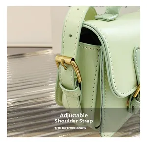Macro shot of mint green shoulder bag featuring adjustable strap and gold metal buckle