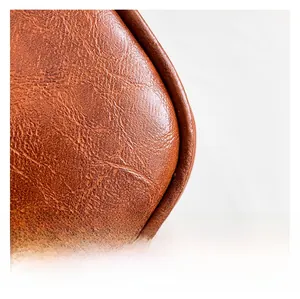 Detail shot of brown lychee grain leather texture with premium stitching on bag