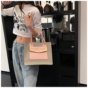 Close-up of stylish grey and pink leather tote bag with yellow contrast piping detail