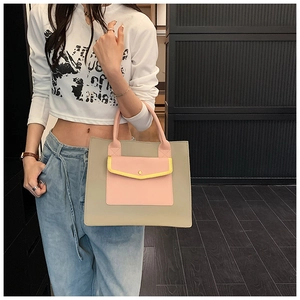 Detail view of the khaki and pink tote bag showing the color-block pocket and leather texture