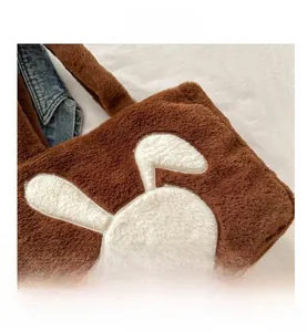 Gros plan du sac fourre-tout en peluche marron avec broderie de lapin blanc mignon