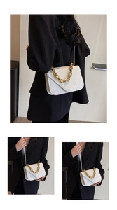 Detail of white crocodile pattern shoulder bag with gold chain and crossbody strap